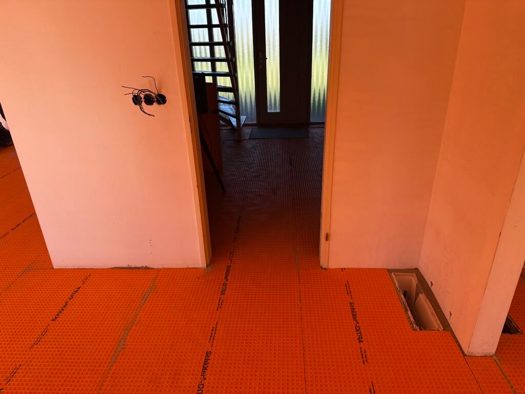 Aanbrengen Schlüter-DITRA ontkoppelingsmat op vloer in Kropswolde ter preventie van scheuren door aardbevingen.