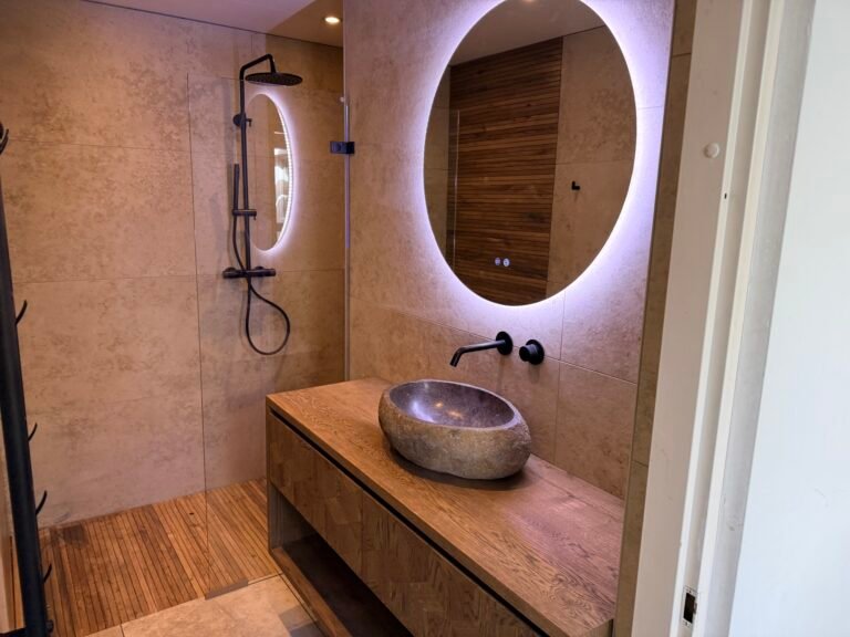 Matzwarte inbouwkraan strak verwerkt in tegelwand boven wastafel